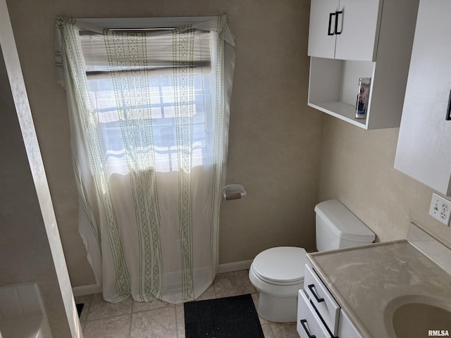 560 4th Ave S, Clinton, IA 52732 - bathroom featuring toilet, vanity, tile patterned flooring, and baseboards