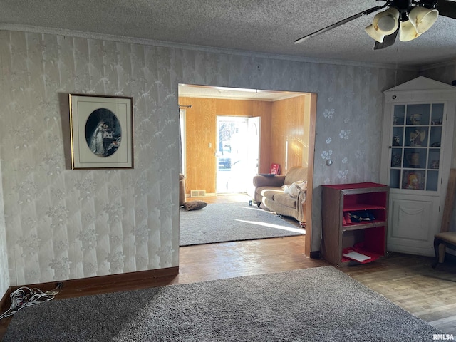 corridor featuring crown molding, a textured ceiling, and hardwood / wood-style flooring