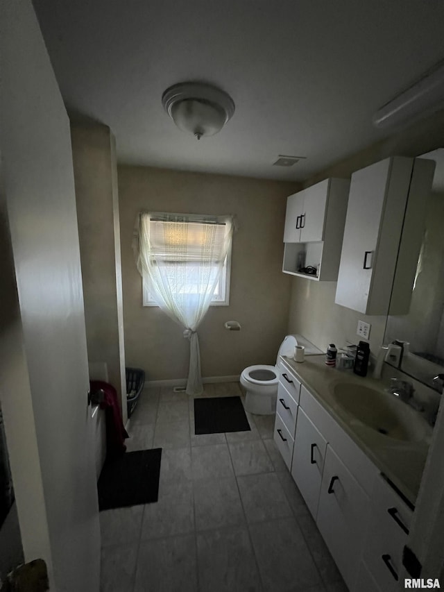 bathroom featuring vanity, toilet, and tile patterned flooring