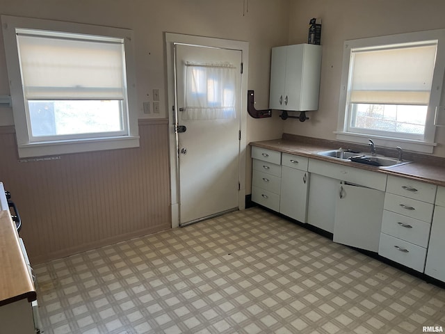 kitchen with plenty of natural light, white cabinetry, sink, and water heater