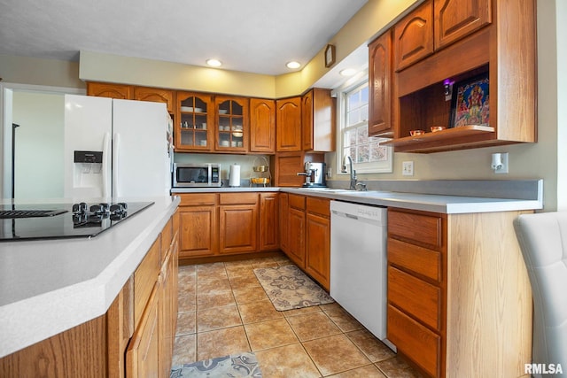 kitchen featuring light tile patterned floors, white appliances, and sink