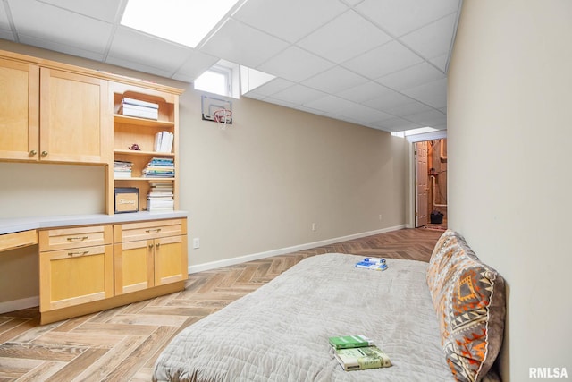 bedroom with a paneled ceiling and built in desk