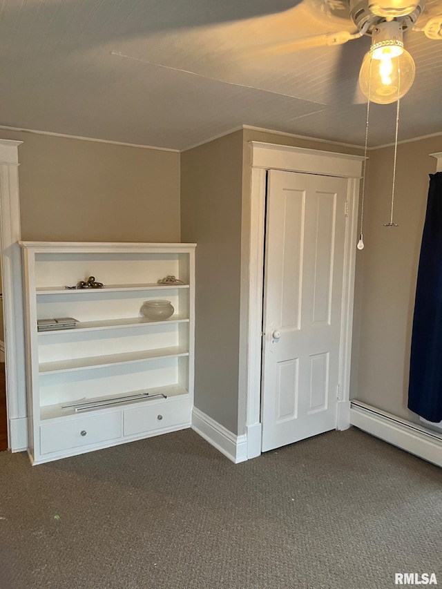 interior space featuring dark carpet, ceiling fan, and a baseboard heating unit