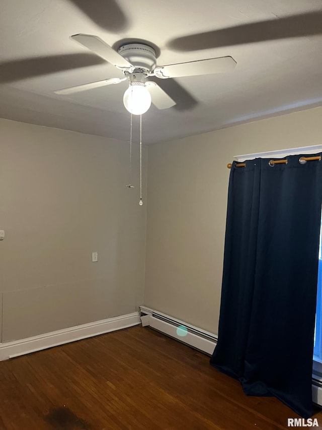 spare room featuring baseboard heating, ceiling fan, and dark hardwood / wood-style flooring