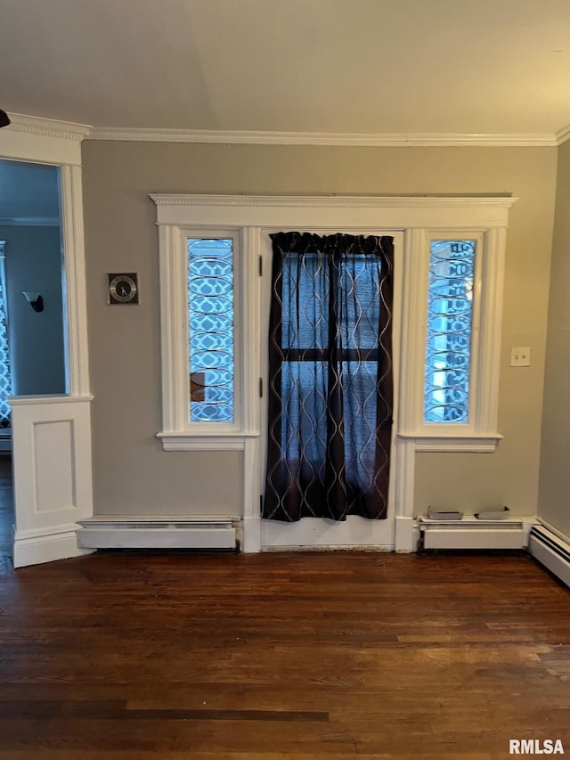 entrance foyer with dark hardwood / wood-style floors, baseboard heating, and crown molding