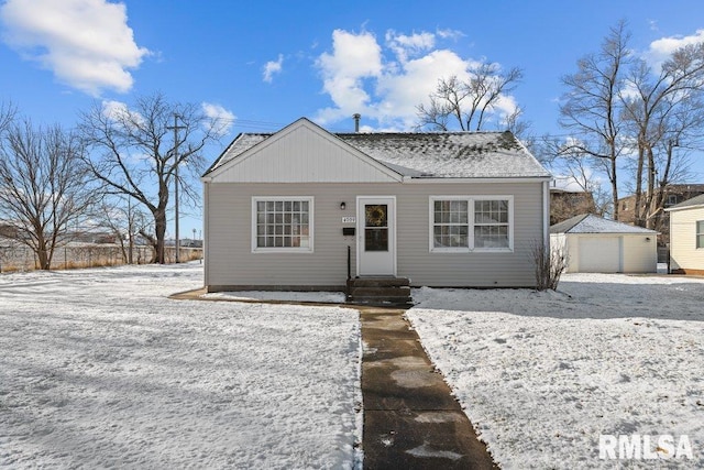 view of front of house featuring a garage and an outbuilding