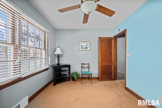 sitting room with ceiling fan and light colored carpet