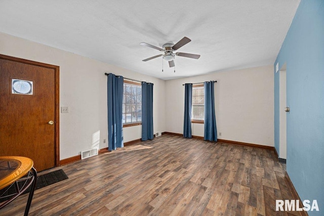 foyer entrance with ceiling fan and dark wood-type flooring