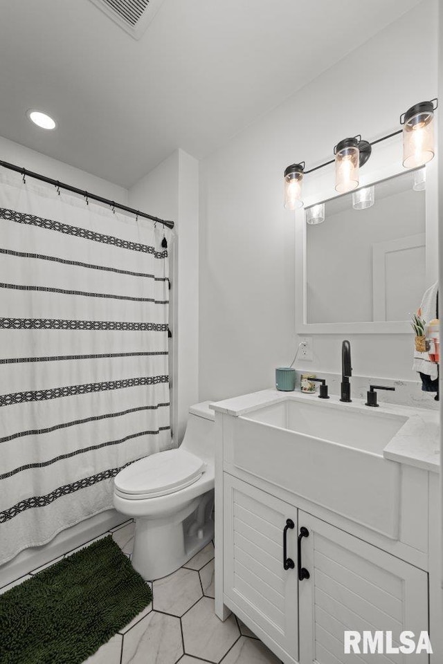 bathroom featuring tile patterned flooring, vanity, curtained shower, and toilet