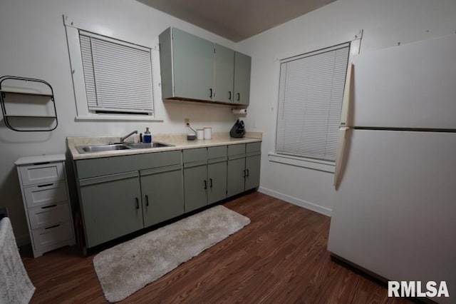 kitchen with white refrigerator, sink, and dark wood-type flooring