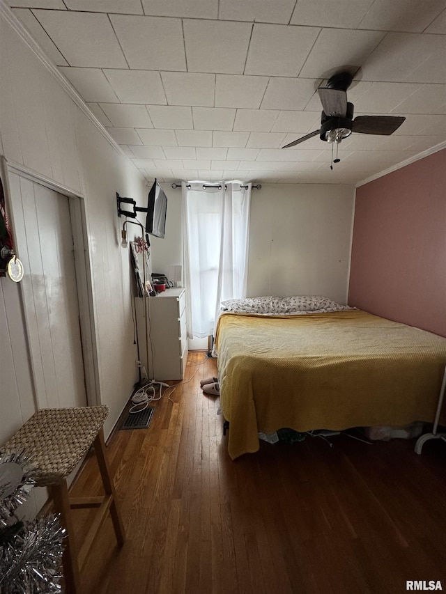 bedroom with ceiling fan, hardwood / wood-style floors, and crown molding