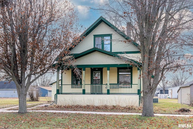 view of front facade with central AC, a porch, and a front yard