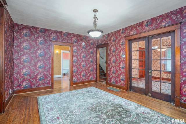 spare room featuring french doors and hardwood / wood-style flooring