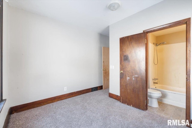 unfurnished bedroom with ensuite bathroom and light colored carpet