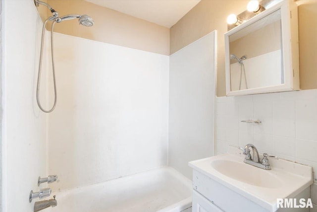 bathroom featuring vanity, backsplash, and shower / bathtub combination