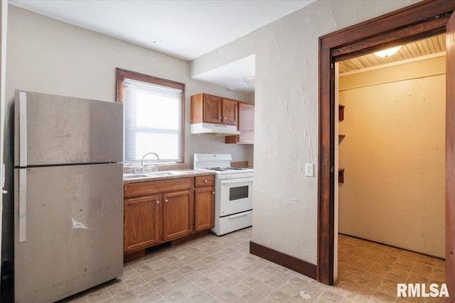 kitchen featuring stainless steel fridge, white range, and sink