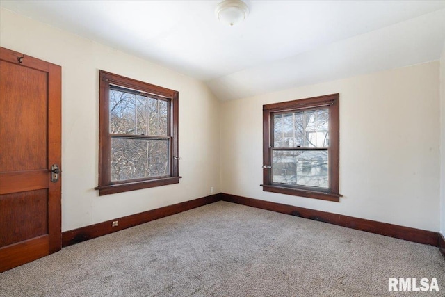 unfurnished room with lofted ceiling and light carpet