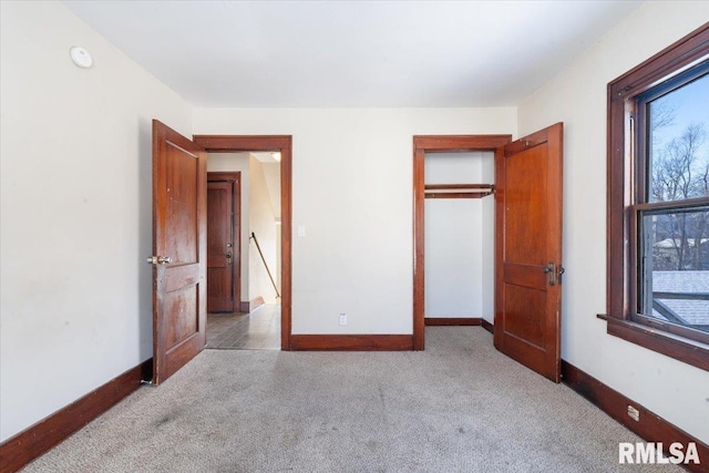 unfurnished bedroom with a closet and light colored carpet