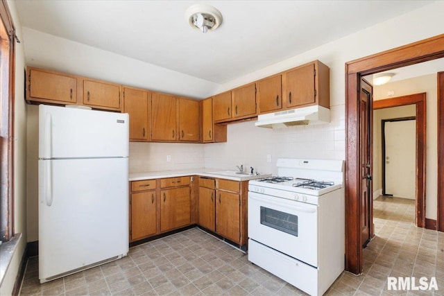 kitchen with sink, white appliances, and backsplash