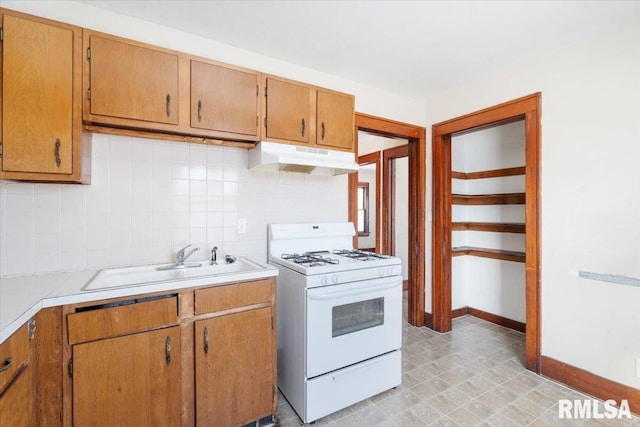 kitchen with decorative backsplash, sink, and white gas range oven