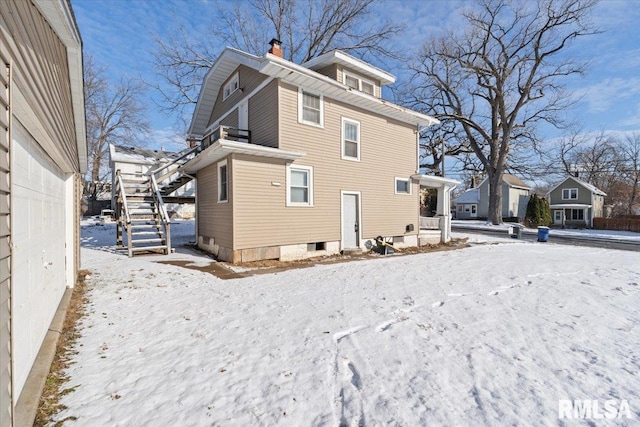 view of snow covered rear of property