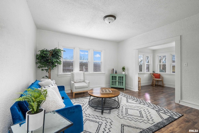 living room featuring dark hardwood / wood-style flooring and a textured ceiling