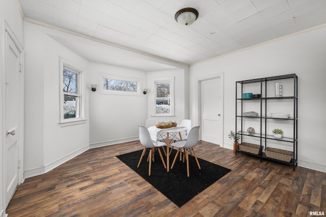 dining room with dark hardwood / wood-style flooring and crown molding