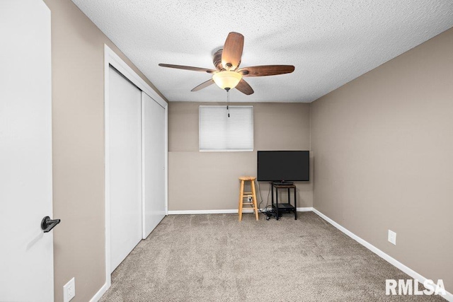 interior space featuring carpet, ceiling fan, and a textured ceiling