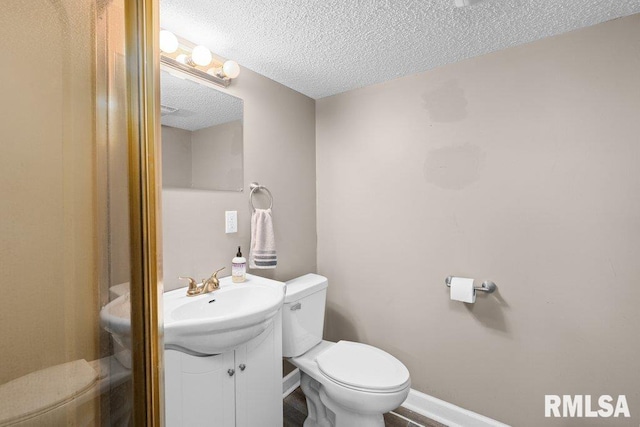 bathroom featuring vanity, a textured ceiling, and toilet