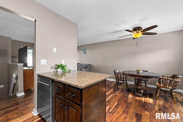 kitchen with dark wood-type flooring, ceiling fan, light stone countertops, a textured ceiling, and dark brown cabinets