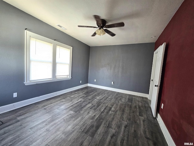 spare room featuring dark wood-type flooring, ceiling fan, and a textured ceiling