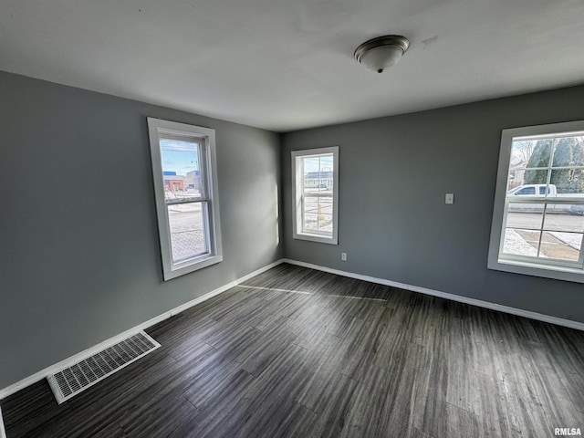 unfurnished room with a healthy amount of sunlight and dark hardwood / wood-style floors