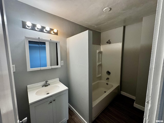 bathroom featuring washtub / shower combination, wood-type flooring, and vanity