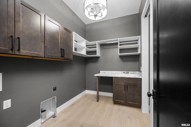 laundry area with cabinets, hookup for an electric dryer, sink, a chandelier, and light hardwood / wood-style floors