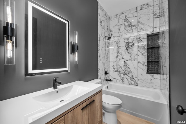 full bathroom with toilet, vanity, and tiled shower / bath