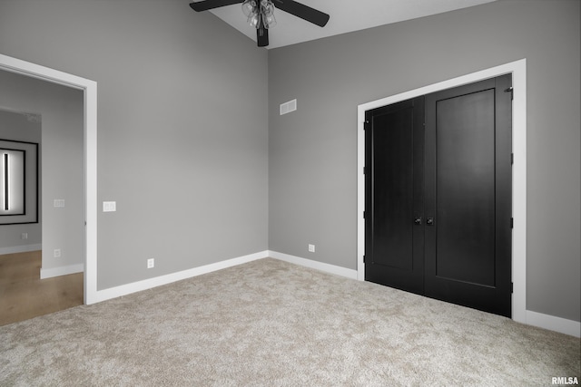 unfurnished bedroom featuring carpet flooring, ceiling fan, a closet, and vaulted ceiling