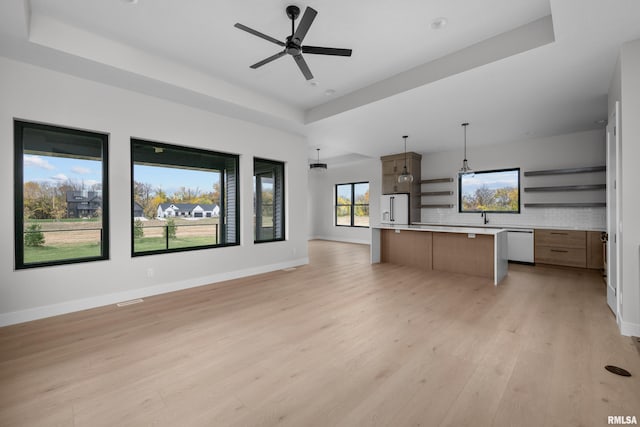 kitchen with a tray ceiling, tasteful backsplash, and hanging light fixtures