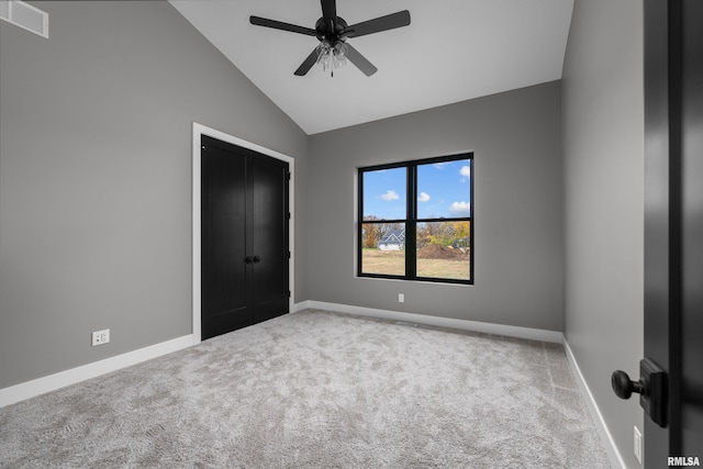 unfurnished bedroom featuring carpet flooring, a closet, ceiling fan, and lofted ceiling