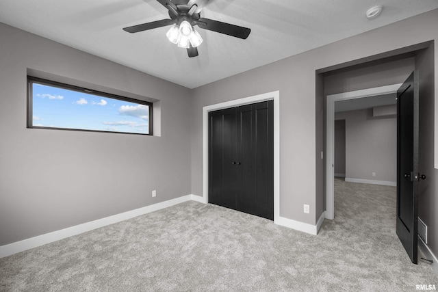 unfurnished bedroom featuring ceiling fan, light carpet, and a closet