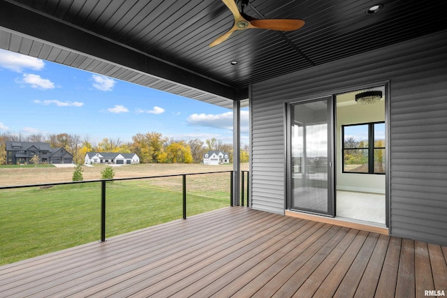 wooden terrace with ceiling fan and a lawn