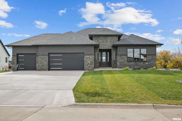 prairie-style home featuring a front yard and a garage