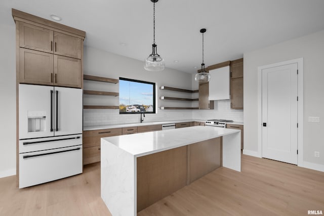 kitchen with sink, decorative backsplash, light wood-type flooring, appliances with stainless steel finishes, and a kitchen island