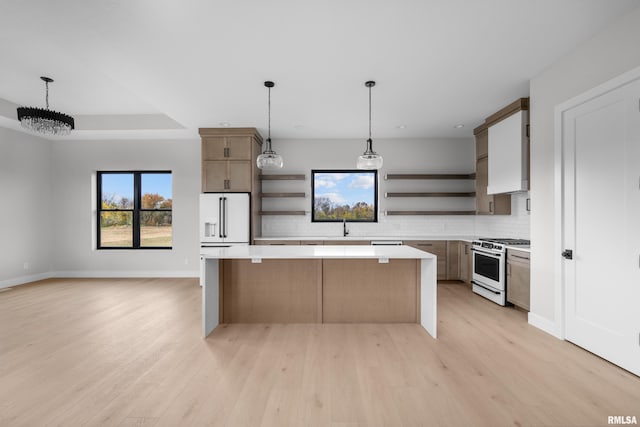 kitchen featuring light hardwood / wood-style floors, decorative light fixtures, a center island, and white appliances