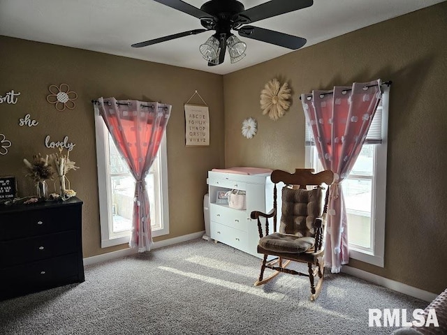 sitting room featuring ceiling fan, plenty of natural light, and carpet