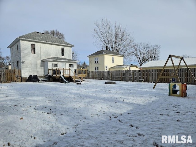 snow covered rear of property with a wooden deck