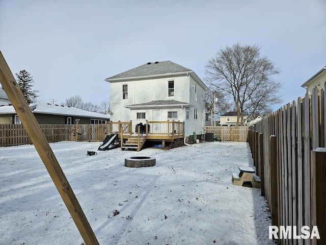 snow covered property with cooling unit, an outdoor fire pit, and a wooden deck