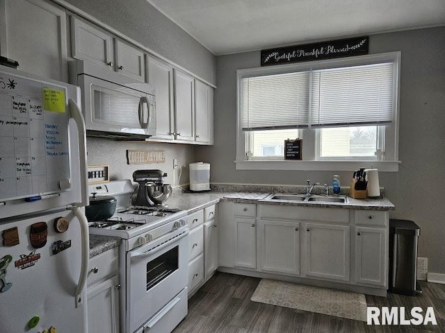 kitchen with dark hardwood / wood-style flooring, white appliances, white cabinetry, and sink