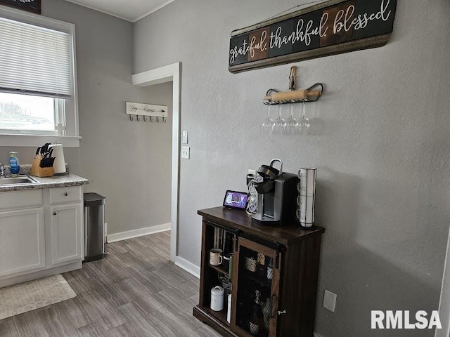 kitchen featuring light hardwood / wood-style floors, white cabinetry, and sink