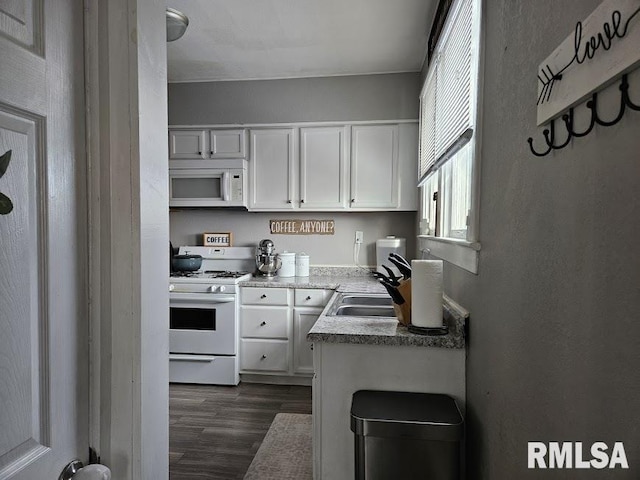 kitchen featuring dark hardwood / wood-style flooring, white cabinetry, sink, and white appliances