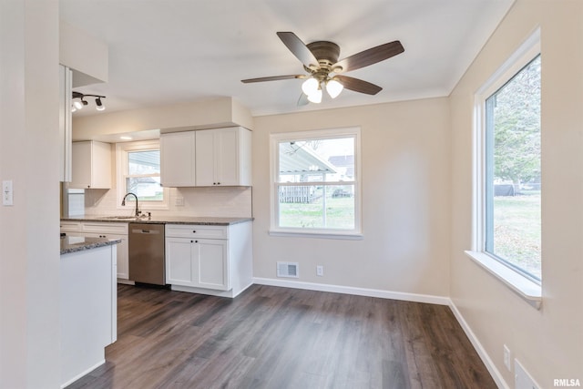 kitchen with dark hardwood / wood-style flooring, backsplash, dark stone counters, dishwasher, and white cabinetry